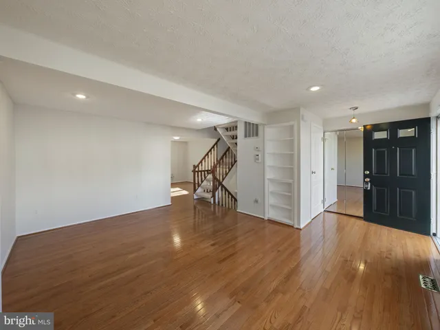 a view of empty room with wooden floor and stairs
