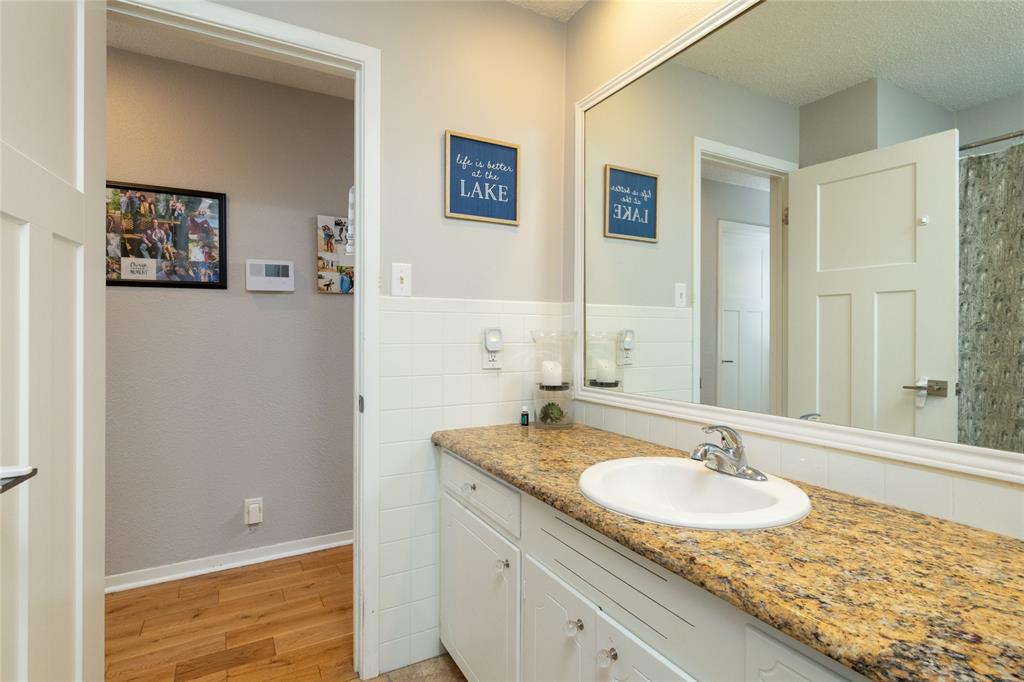 205 Timberlake Drive Azle, TX 76020 - Photo 14 of 40 a bathroom with a granite countertop sink and a mirror