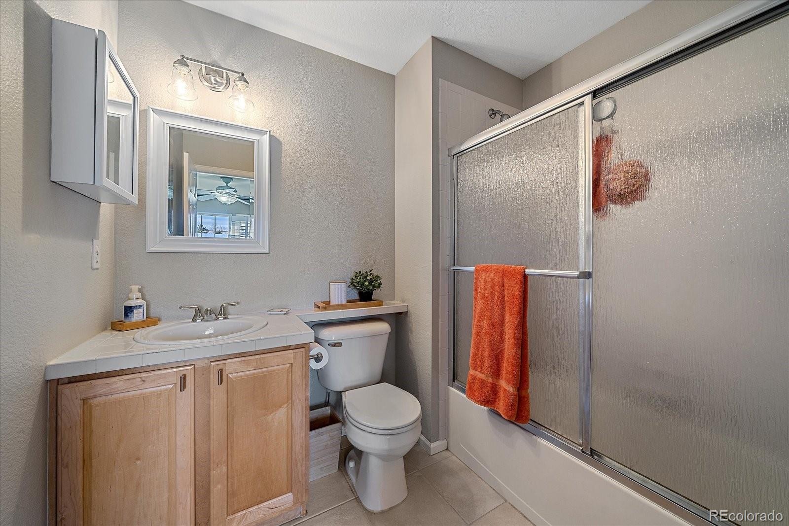 6318 Trailhead Road Highlands Ranch, CO 80130 - Photo 23 of 32 a bathroom with a toilet sink vanity and shower