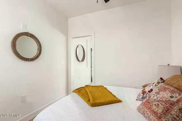 a bedroom with a bed and a lamp on the dresser