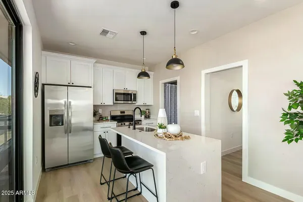 a kitchen with refrigerator cabinets and wooden floor