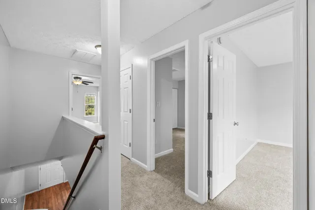 a view of a hallway with closet and bathroom