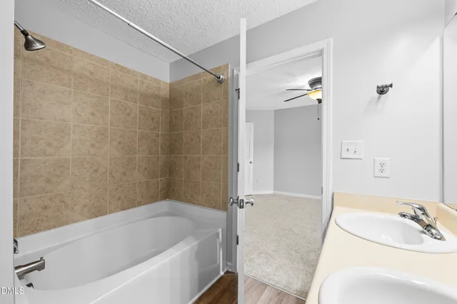 a bathroom with a tub a sink and a shower