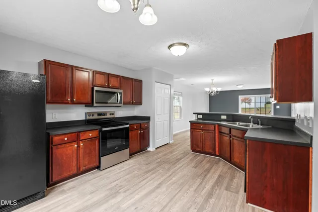a large kitchen with stainless steel appliances granite countertop a stove sink and refrigerator
