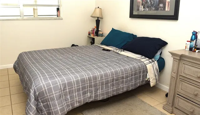 a bedroom with a bed and a painting on the wall