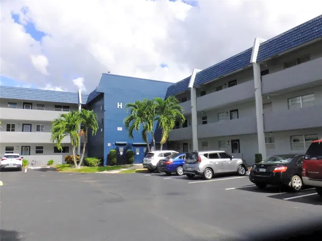 a view of a cars park in front of a building