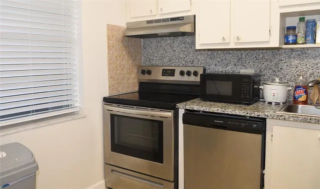 a stove top oven sitting inside of a kitchen