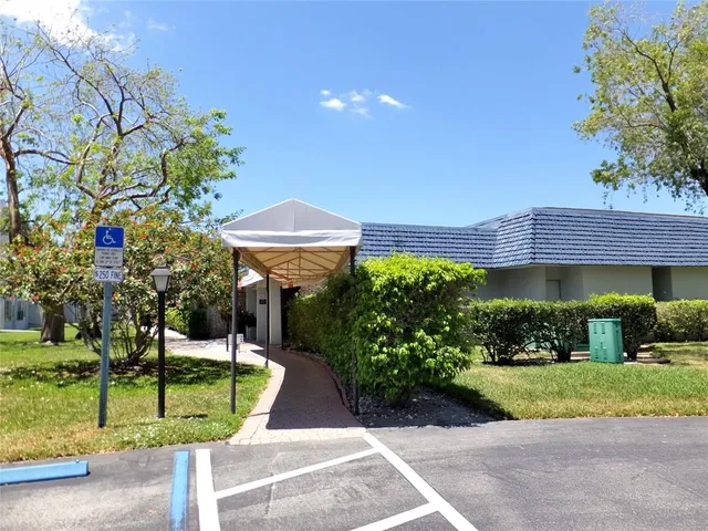 a front view of a house with a yard and potted plants