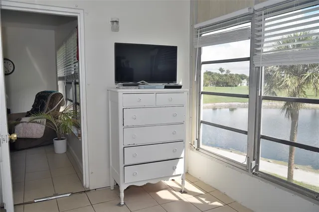 a room with a flat screen tv potted plant and a large window