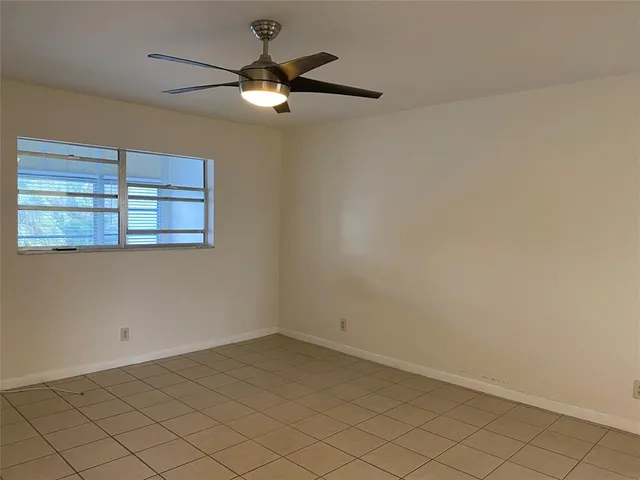 an empty room with a chandelier fan