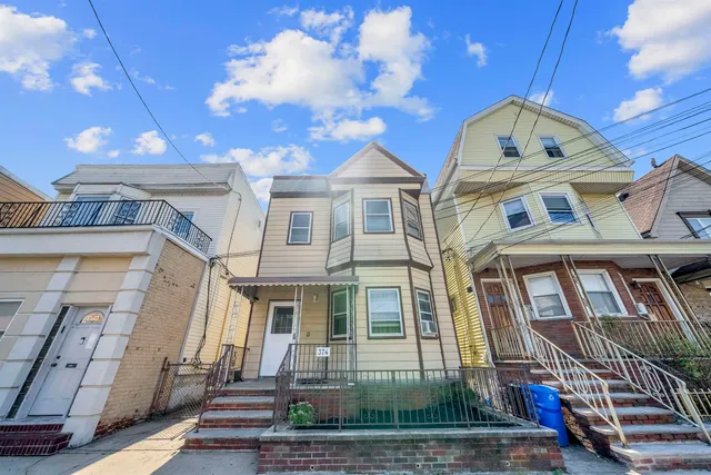 a front view of a residential apartment building with a yard
