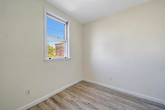 a view of a room that has wooden floor and window