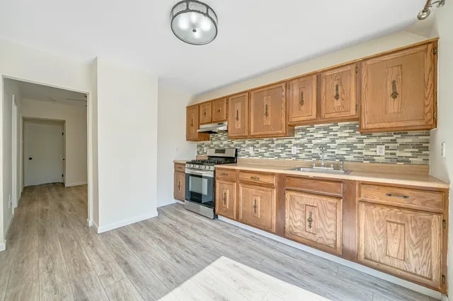 a kitchen with granite countertop wooden cabinets a sink and dishwasher
