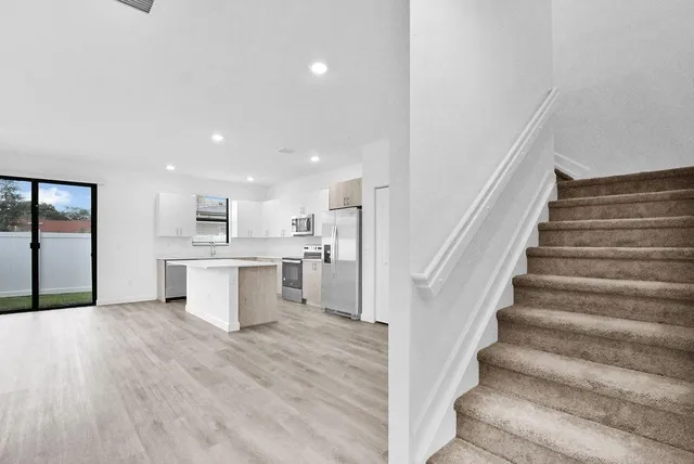 a view of a kitchen with wooden floor and electronic appliances
