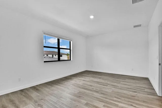 wooden floor in an empty room with a window