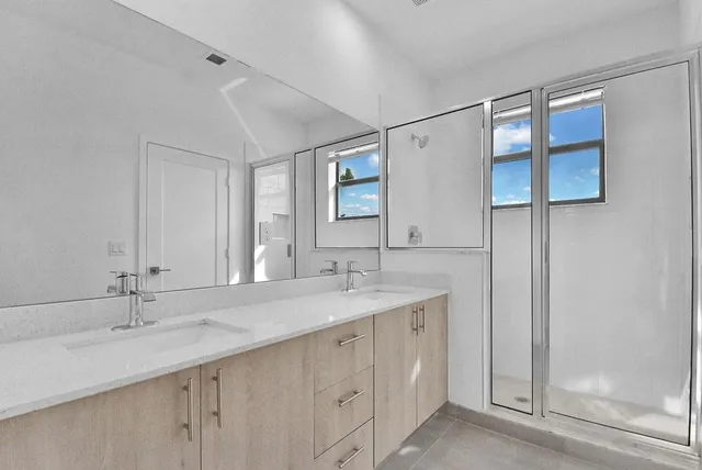 a bathroom with a double vanity sink and a mirror