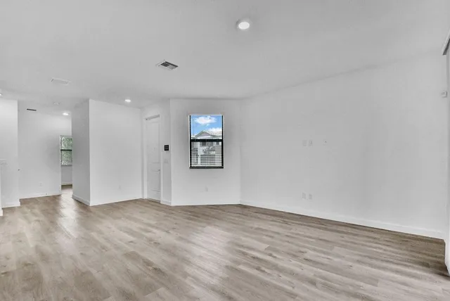 a view of an empty room with wooden floor