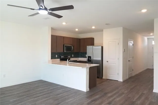 a kitchen with stainless steel appliances a refrigerator and a stove top oven