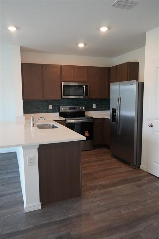 2476 Riversong Ldg Lane Wesley Chapel, FL 33543 - Photo 7 of 22 a kitchen with kitchen island stainless steel appliances a sink cabinets and a counter top space