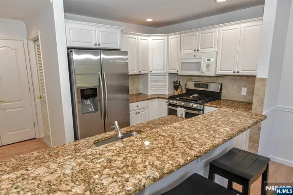 a kitchen with kitchen island sink refrigerator and cabinets