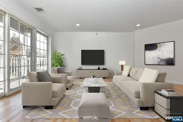 a living room with furniture flat screen tv and a large window