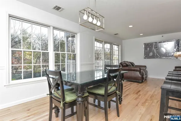 a dining room with furniture a chandelier and wooden floor