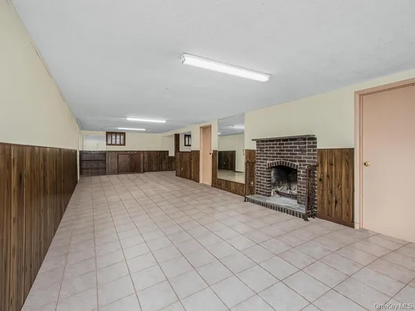 a view of empty room with fireplace and wooden floor