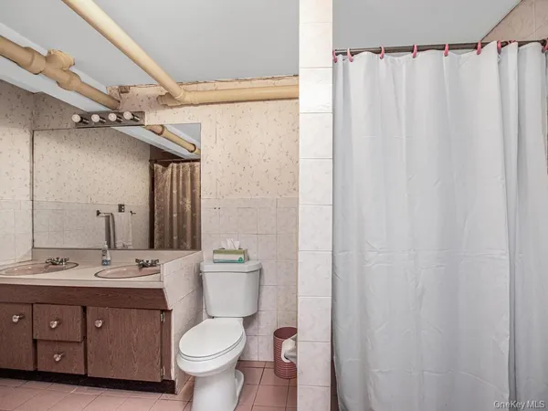 a bathroom with a toilet a sink and a mirror