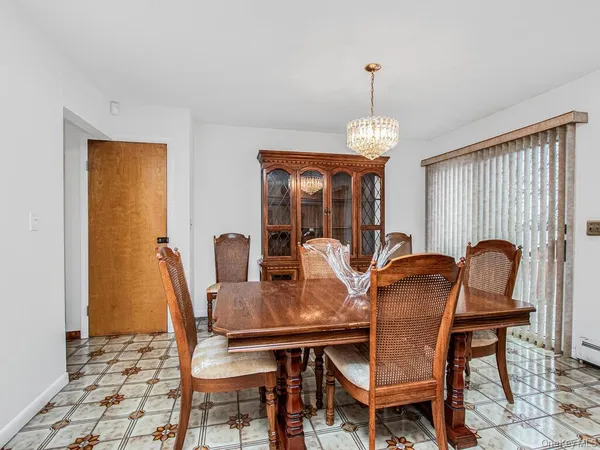 a dining room with furniture a chandelier and window