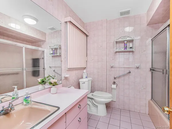 a bathroom with a granite countertop sink a toilet and shower