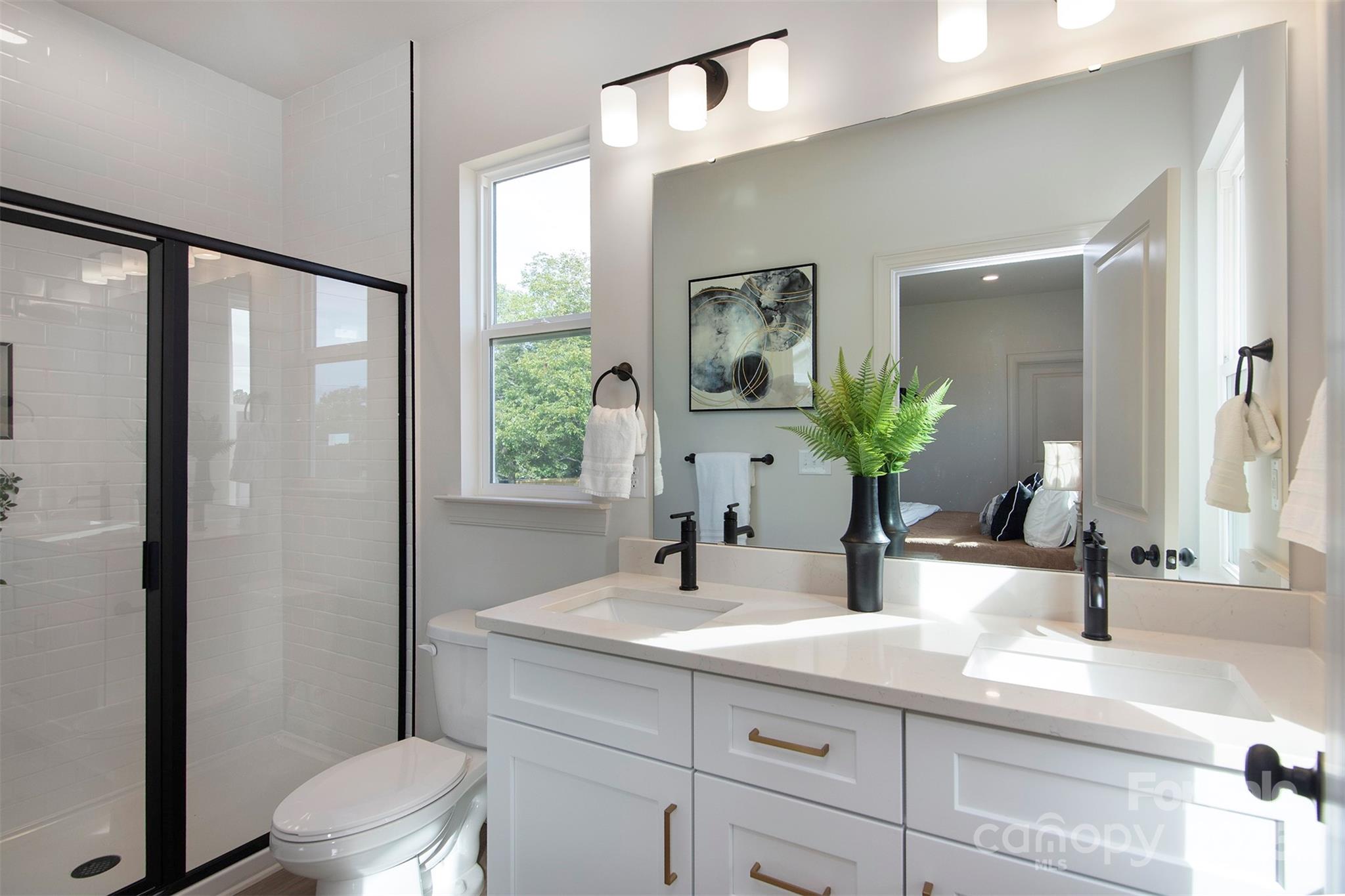 118 Durham Road Stanley, NC 28164 - Photo 19 of 24 a bathroom with a sink a toilet a large mirror and shower