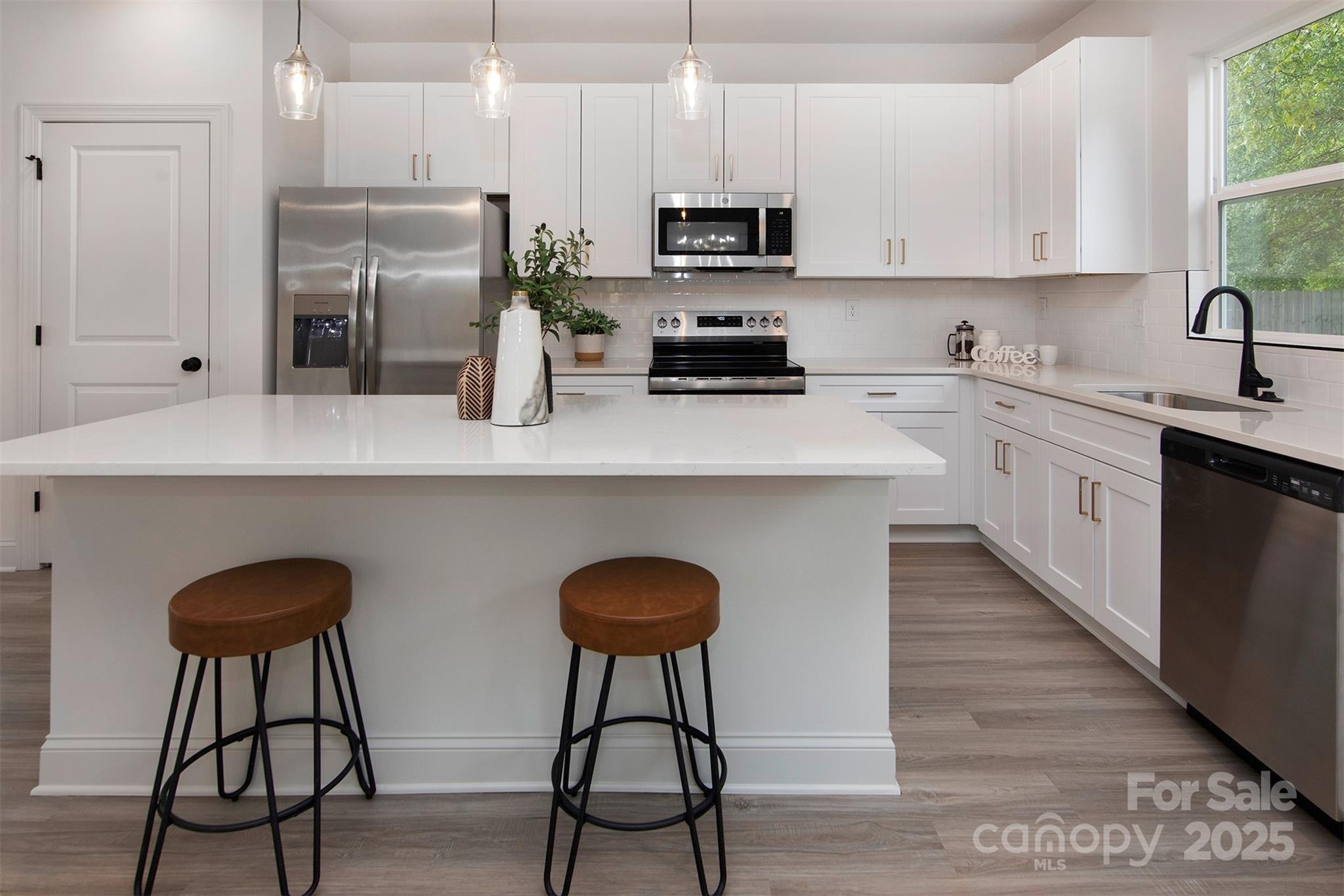 118 Durham Road Stanley, NC 28164 - Photo 7 of 24 a kitchen with stainless steel appliances white cabinets a sink and a stove