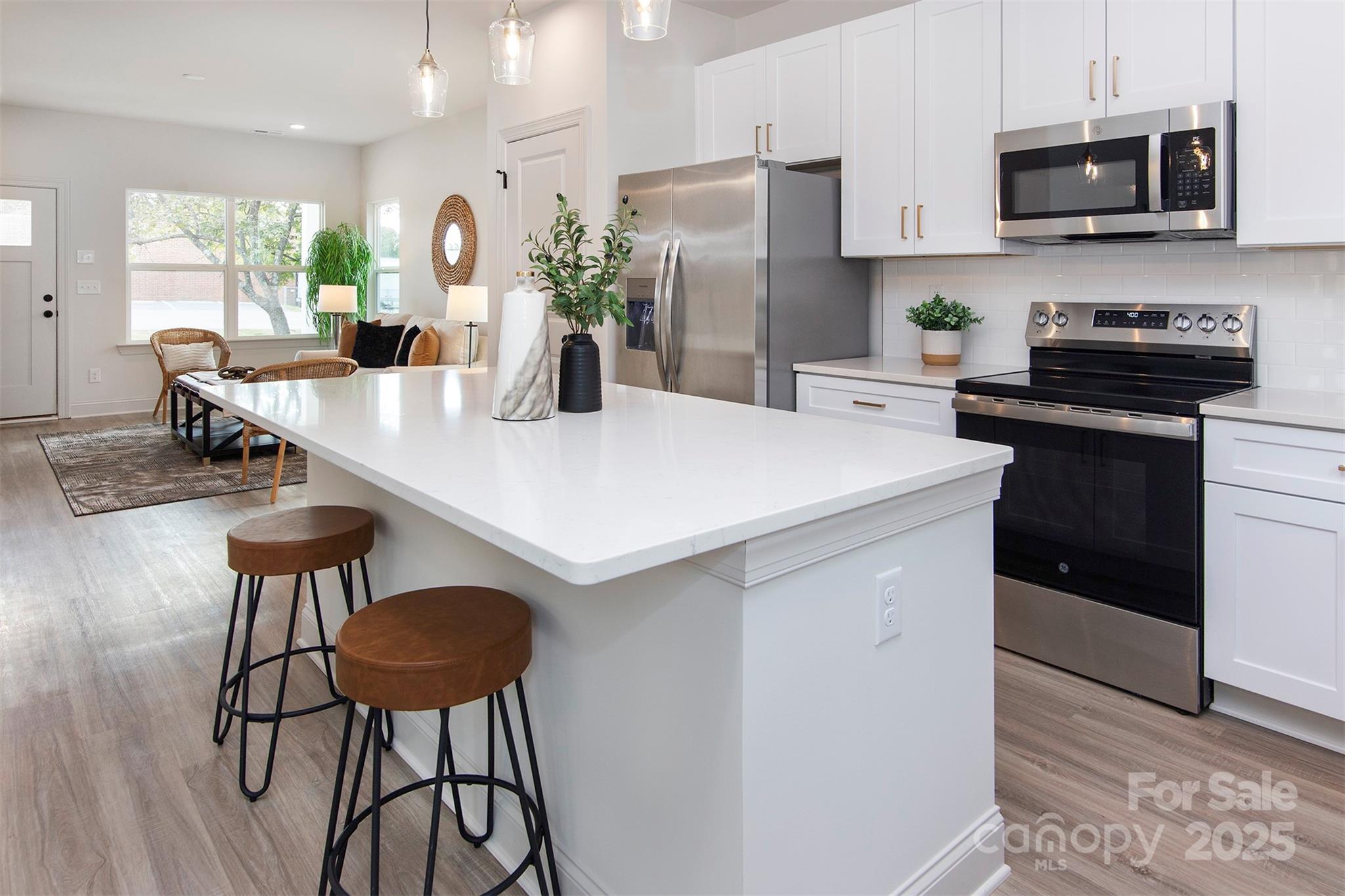118 Durham Road Stanley, NC 28164 - Photo 9 of 24 a kitchen with stainless steel appliances a table chairs microwave and cabinets