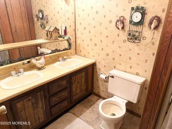a bathroom with a toilet a sink and mirror