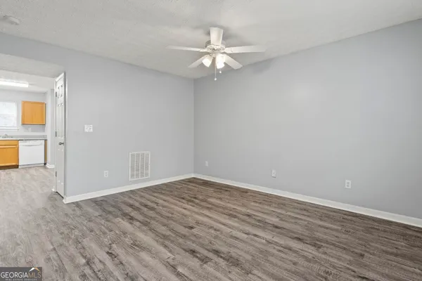 a view of an empty room with wooden floor