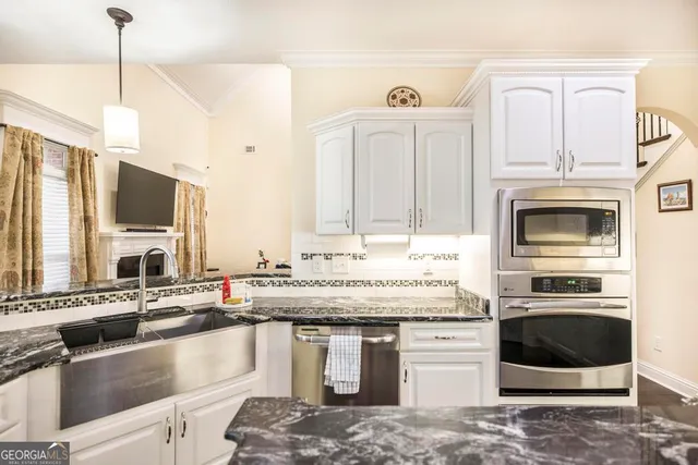 a kitchen with stainless steel appliances granite countertop a sink stove and microwave