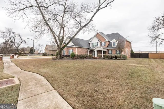 a front view of residential houses with yard and trees