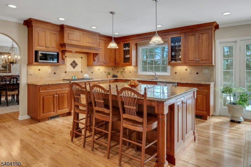 31 Garfield Avenue Madison, NJ 07940 - Photo 15 of 47 a kitchen with stainless steel appliances granite countertop a kitchen island a stove a table and chairs in it