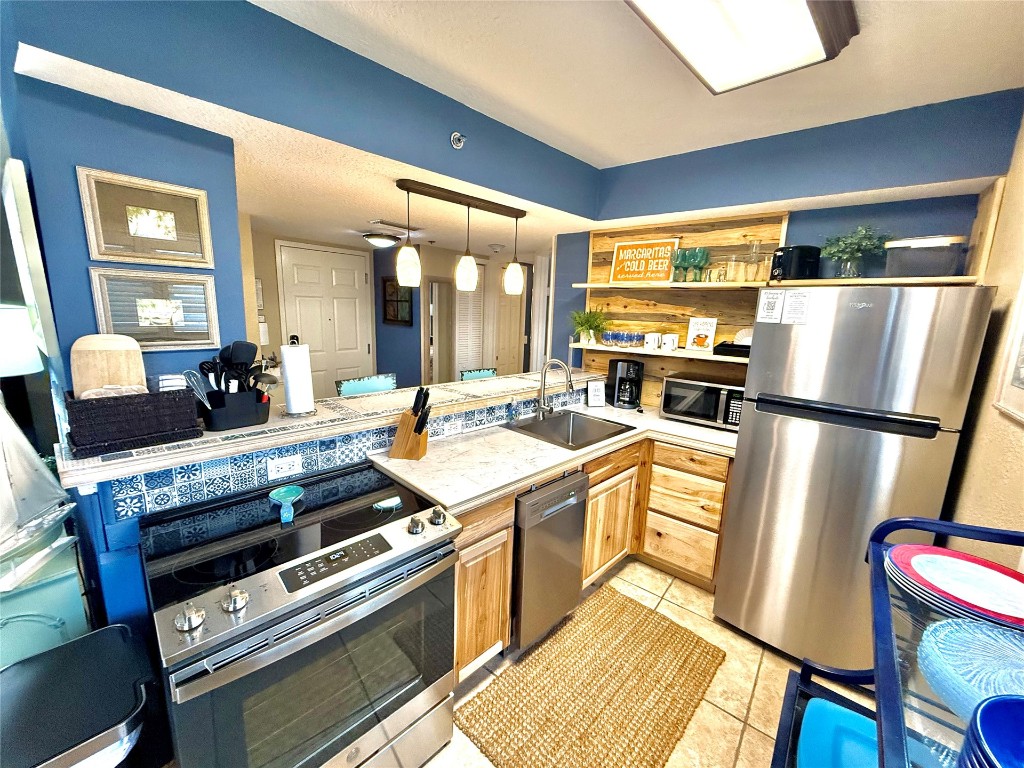 32 South Fletcher Avenue, Unit 105 Fernandina Beach, FL 32034 - Photo 5 of 16 a kitchen with a stove a sink and a refrigerator