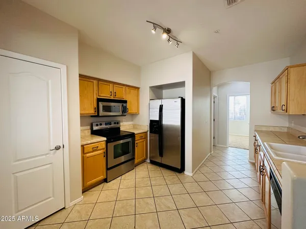 a kitchen with stainless steel appliances granite countertop a refrigerator and a stove top oven