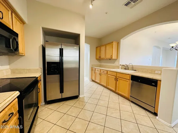 a kitchen with stainless steel appliances granite countertop a refrigerator and a stove