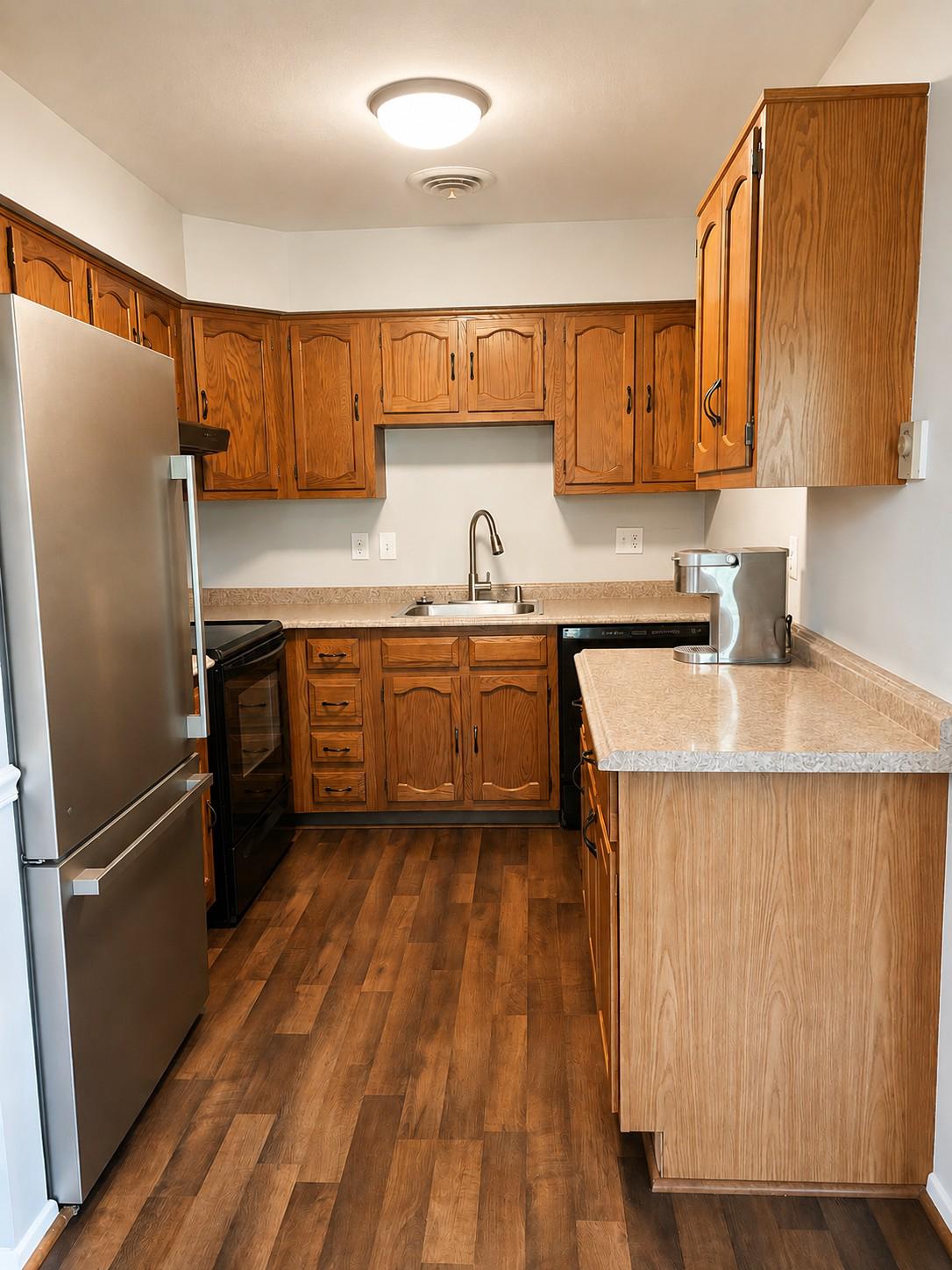 7006 Basswood Road Frederick, MD 21703 - Photo 6 of 10 a kitchen with stainless steel appliances granite countertop a refrigerator a sink dishwasher a stove with wooden cabinets and floor