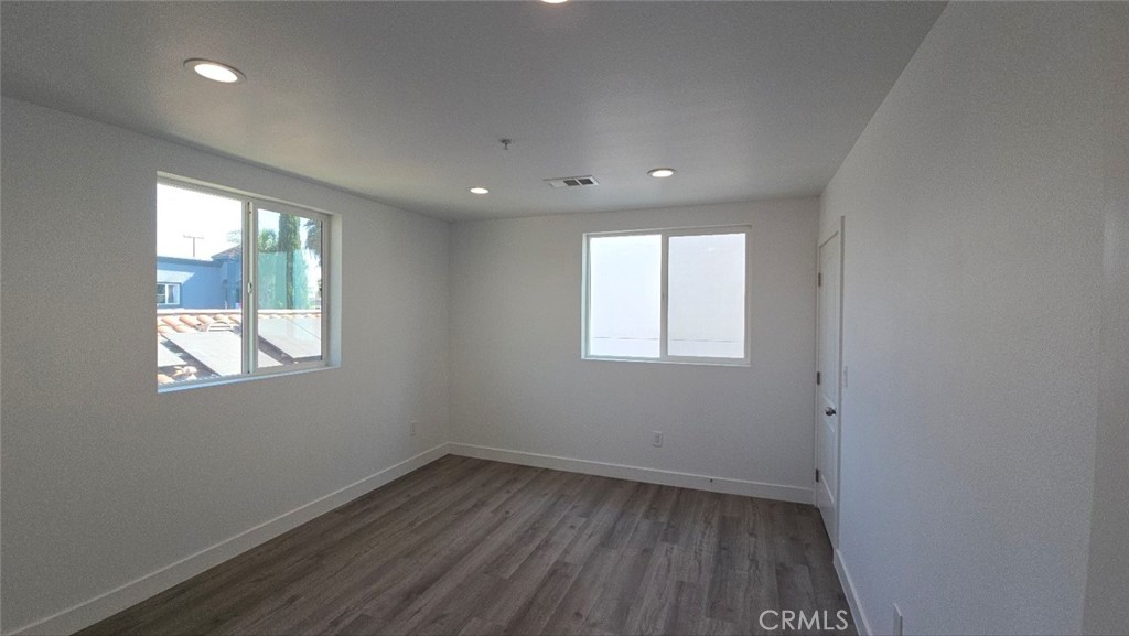 10415 1/2 Avalon Boulevard Los Angeles, CA 90003 - Photo 20 of 24 an empty room with wooden floor and windows
