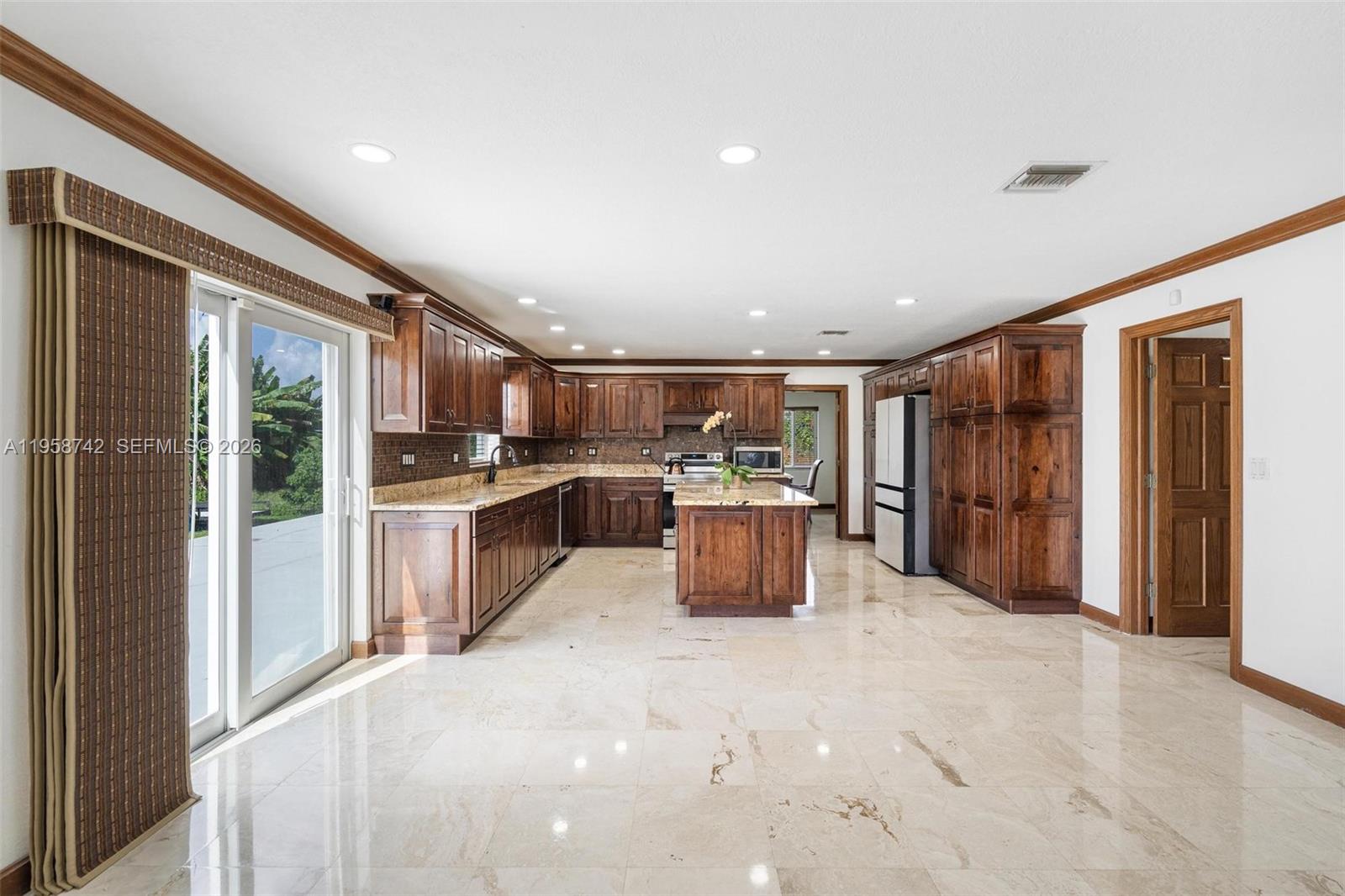 20520 Southwest 190th Street Miami, FL 33187 - Photo 11 of 39 a kitchen with stainless steel appliances kitchen island granite countertop a refrigerator and a stove top oven