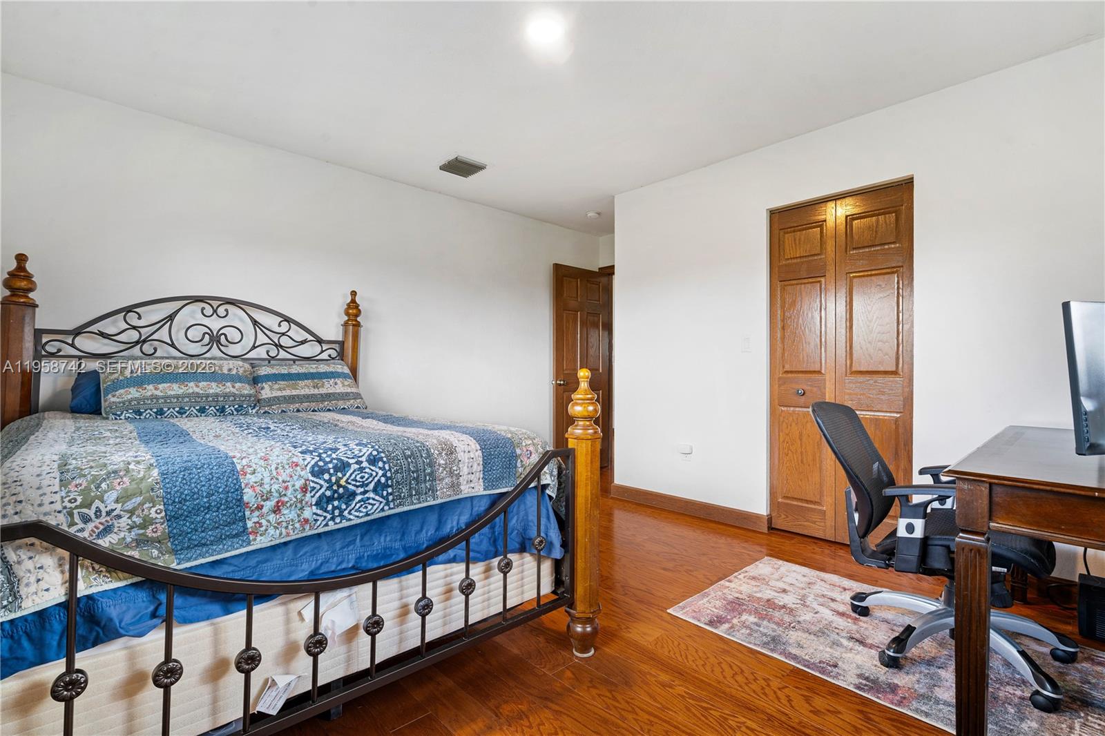 20520 Southwest 190th Street Miami, FL 33187 - Photo 30 of 39 a bedroom with a bed a rug and wooden floor