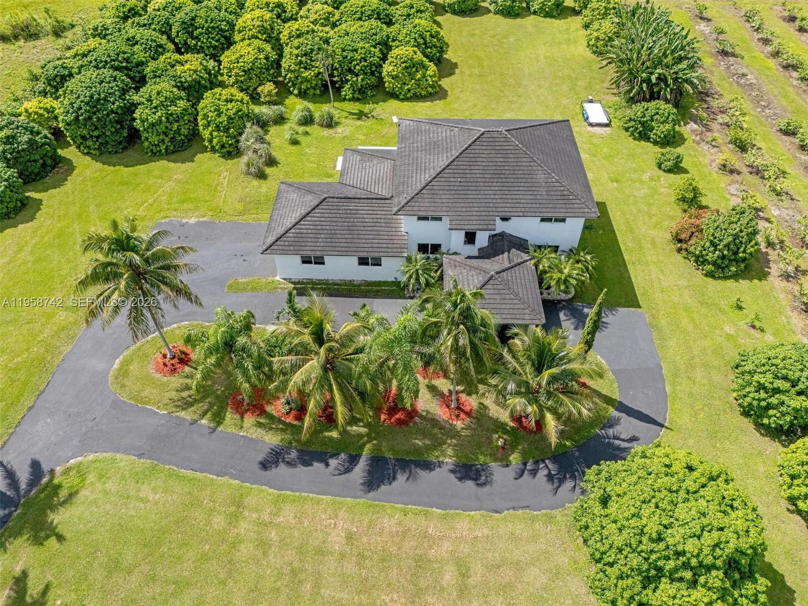 20520 Southwest 190th Street Miami, FL 33187 - Photo 4 of 39 an aerial view of a house with a garden and lake view