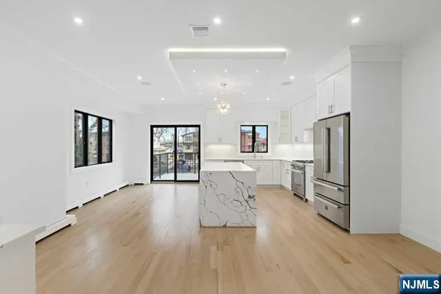 a view of an empty room with wooden floor and stairs