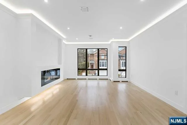 a view of an empty room with a fireplace and a window
