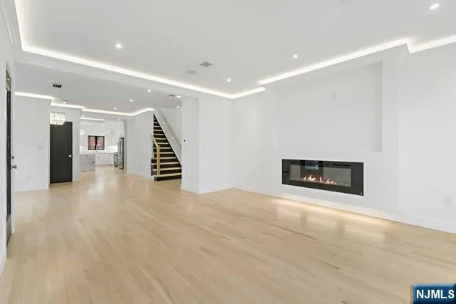 a large kitchen with stainless steel appliances kitchen island granite countertop a stove a sink a refrigerator and white cabinets