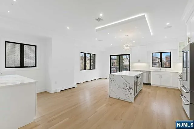 a large kitchen with stainless steel appliances granite countertop a large counter top and a stove top oven